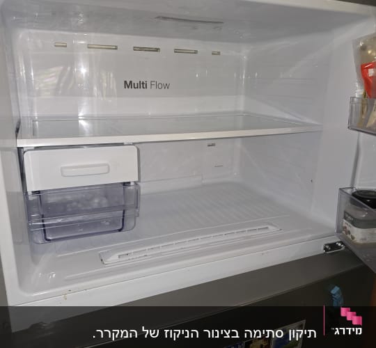 תא מקרר ריק עם מדפים ומדבקות על הדלת